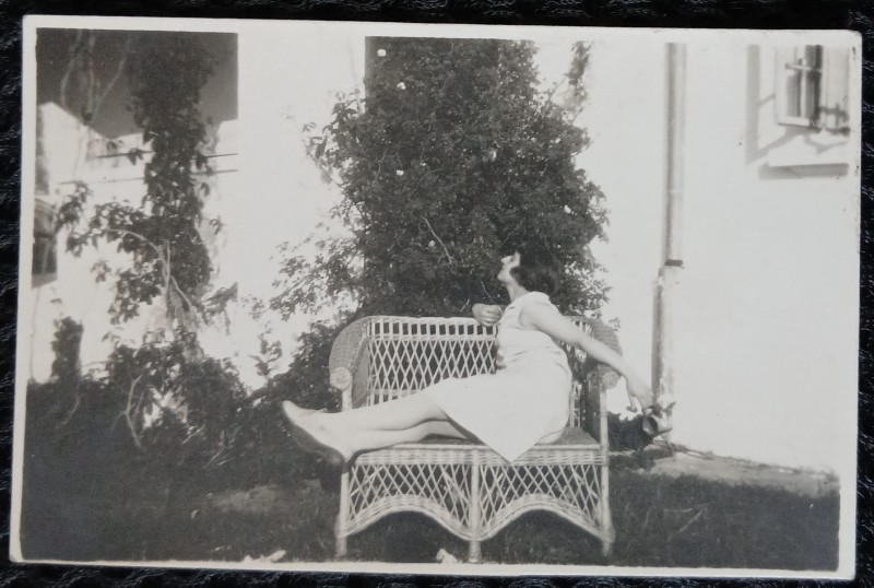 Fotografie, Tanara in gradina pe banca din rafie, perioada interbelica