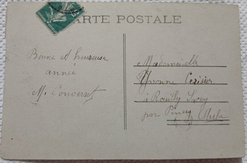Fotografie tip Carte postala, barbat si femeie langa un cos cu flori, perioada interbelica
