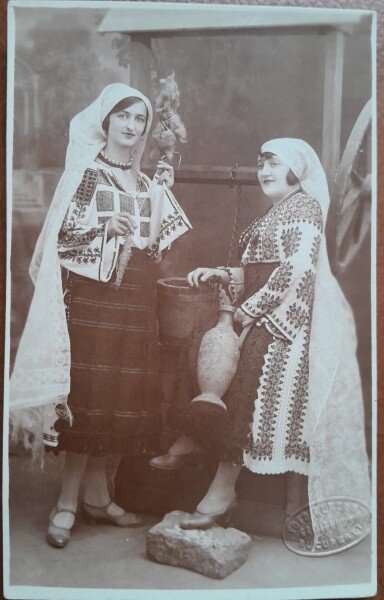 Fotografie tip carte postala, doua tinere in port popular romanesc, perioada interbelica