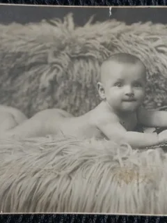 Fotografie tip Carte Postala, Bebelus nud, intins pa o blana, 1924
