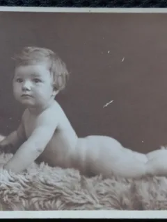 Fotografie tip Carte postala, Bebelus stand pe burta pe o blana, perioada interbelica