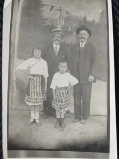Fotografie tip Carte Postala, Doi barbati cu doi copii in costume traditionale romanesti, perioada interbelica